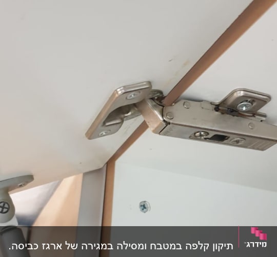 ציר מתכת מחובר לדלת ארון לבנה